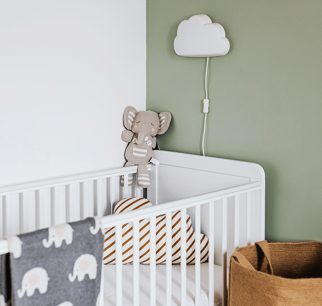 Chambre de bébé épurée avec peinture saine écoresponsable vert sauge sur le mur.