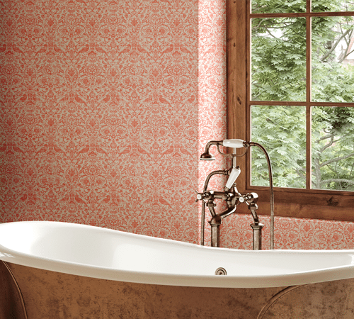 Papier peint traditionnel à motifs floraux orange et blanc posé sur le mur d'une salle de bain près d'une baignoire rétro.